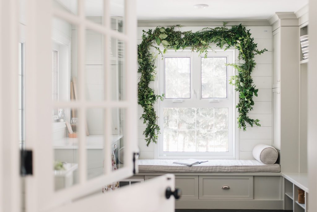 large window framed with fresh green garland