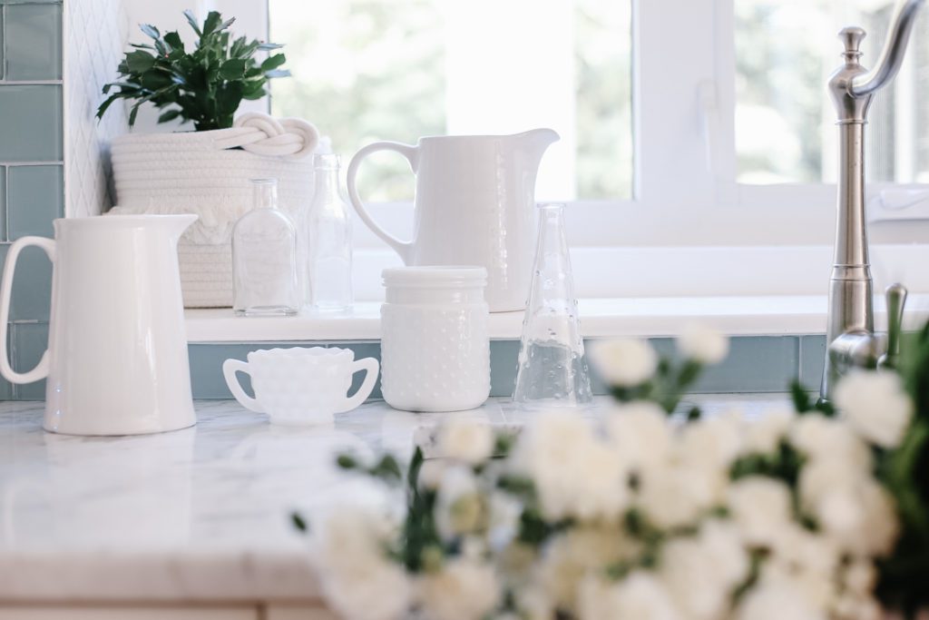 an assortment of white vases, pitchers and containers