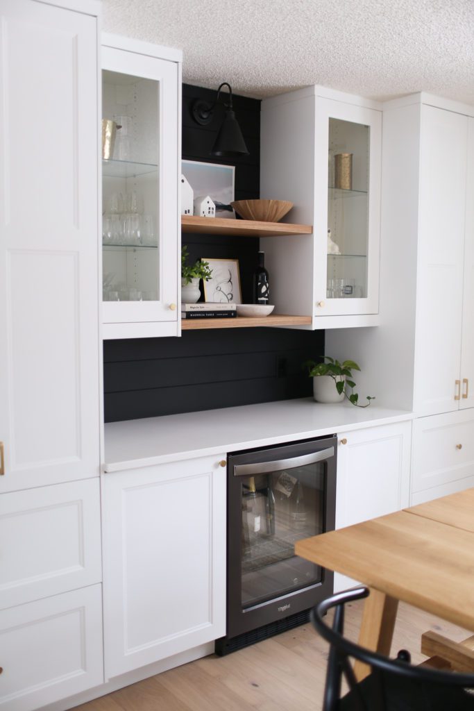 A built-in bar area with wine fridge and open shelving