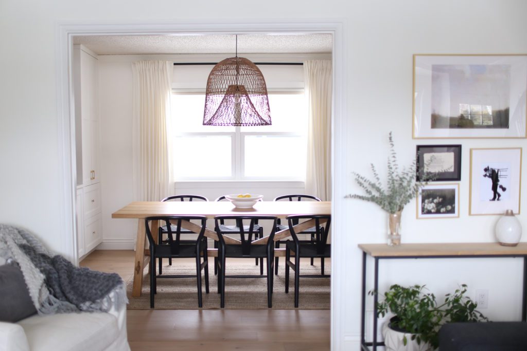 A dining room with large oversize rattan pendant
